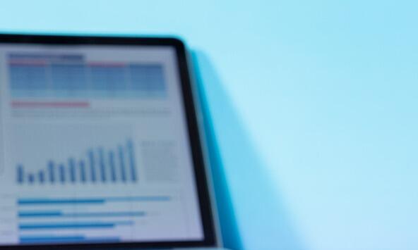 Laptop with blurred screen showing excel spreadsheet data